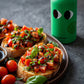 Tomato bruschetta with fresh basil and a drizzle of basil olive oil on a dark ceramic platter