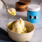Vanilla ice cream with olive oil and sea salt flakes, a spoonful lifted above the bowl